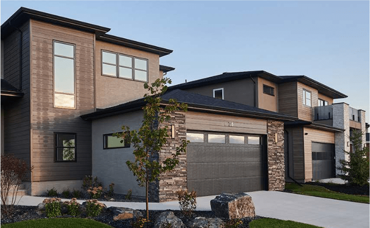 Modern multi-story residential houses with garages, stone accents, and landscaped front yards.