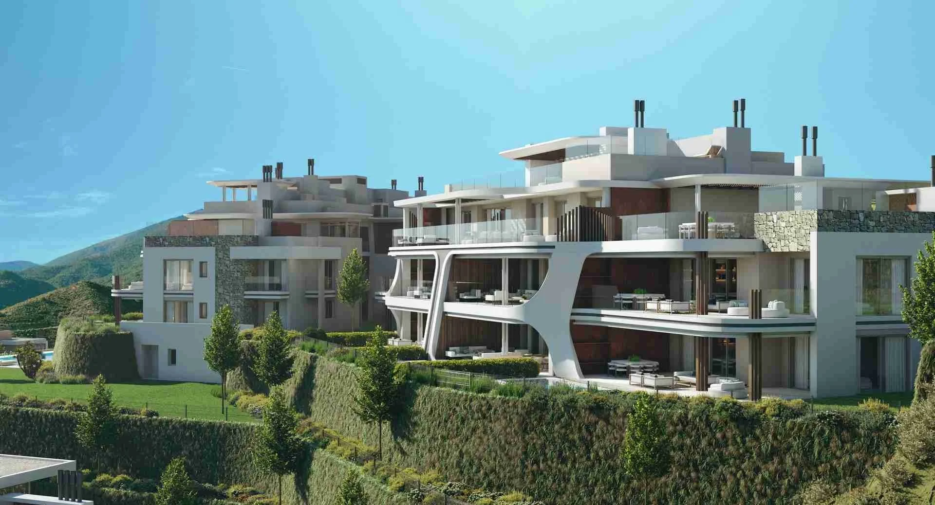 Modern multi-story residential building at Enebros Real de La Quinta, Benahavís with large glass balconies and landscaped gardens