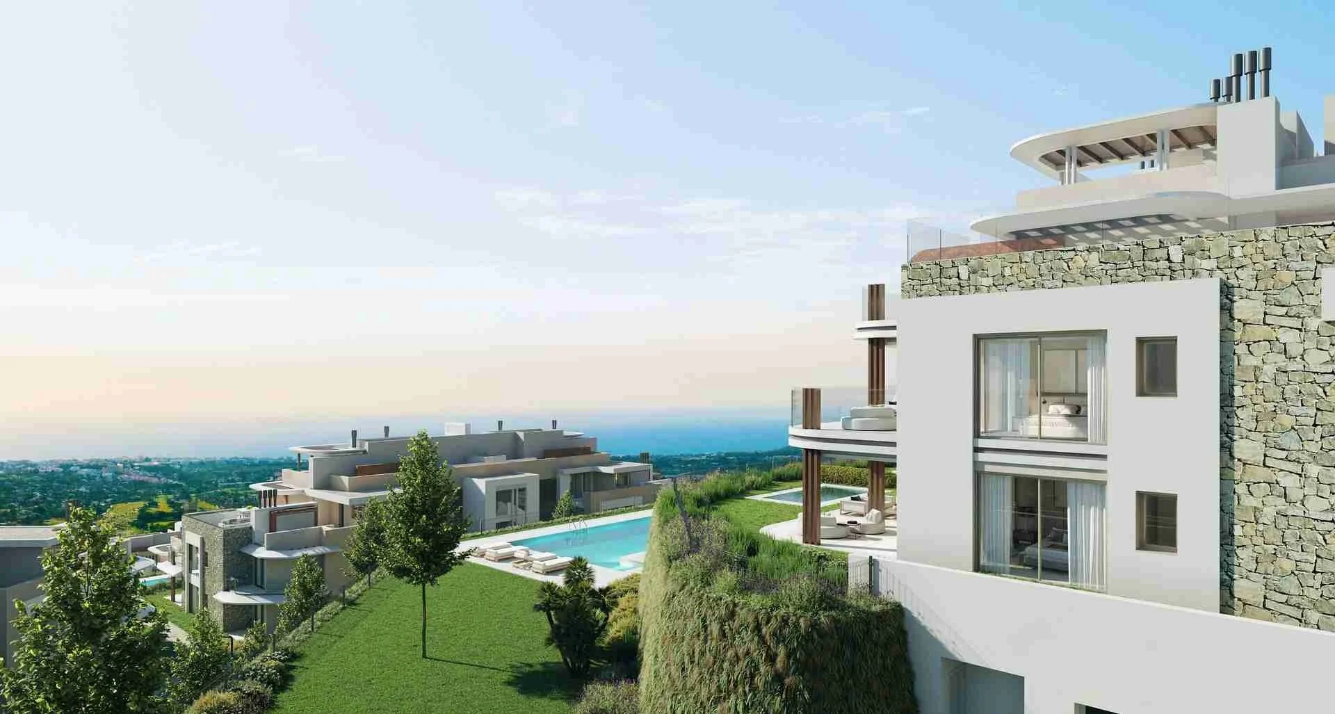 Enebros Real de La Quinta apartments with outdoor pool, green lawns, and distant cityscape views in Benahavís Marbella