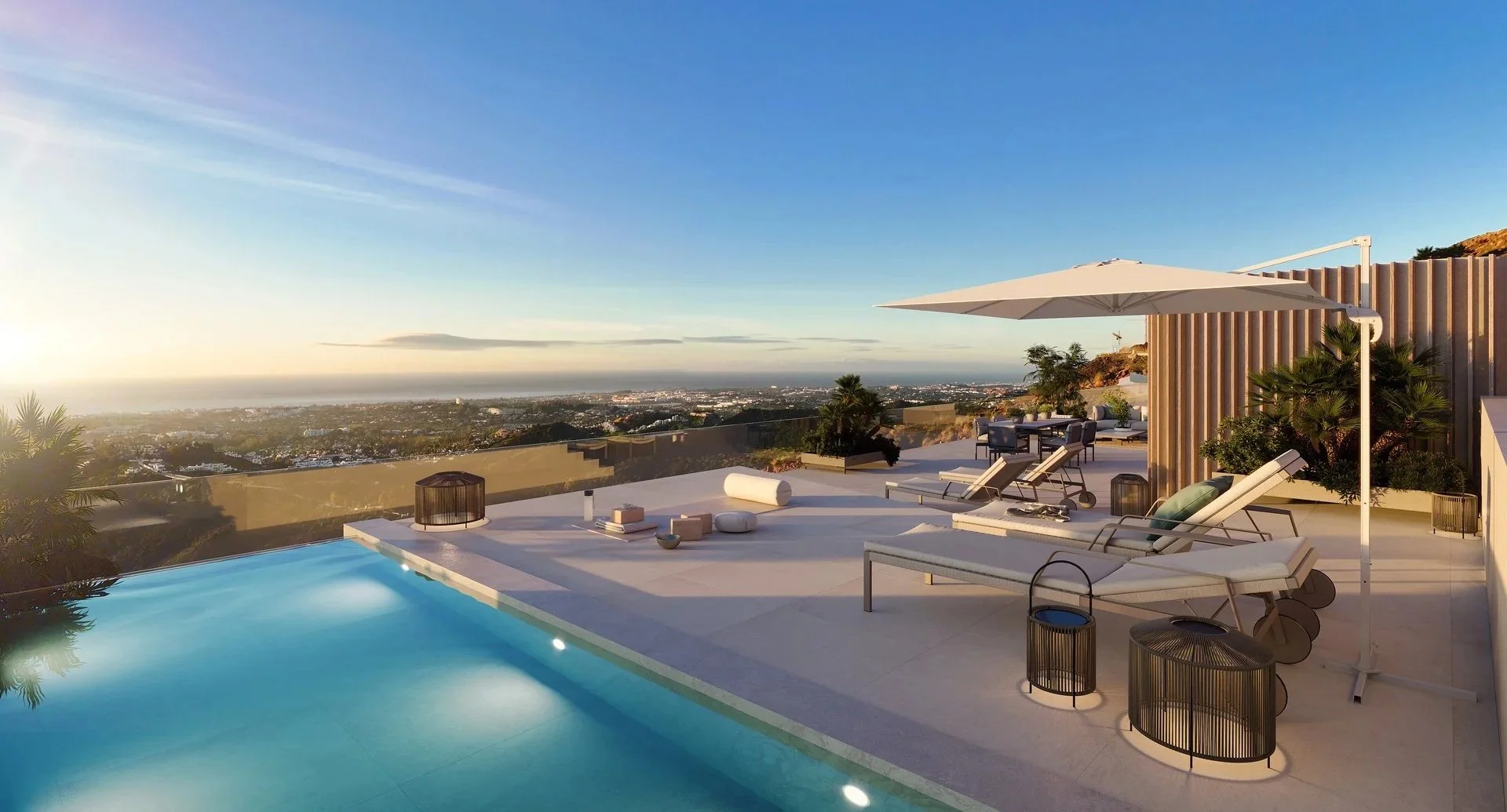 Rooftop pool in Marbella with lounge area and sunset views over the city and sea