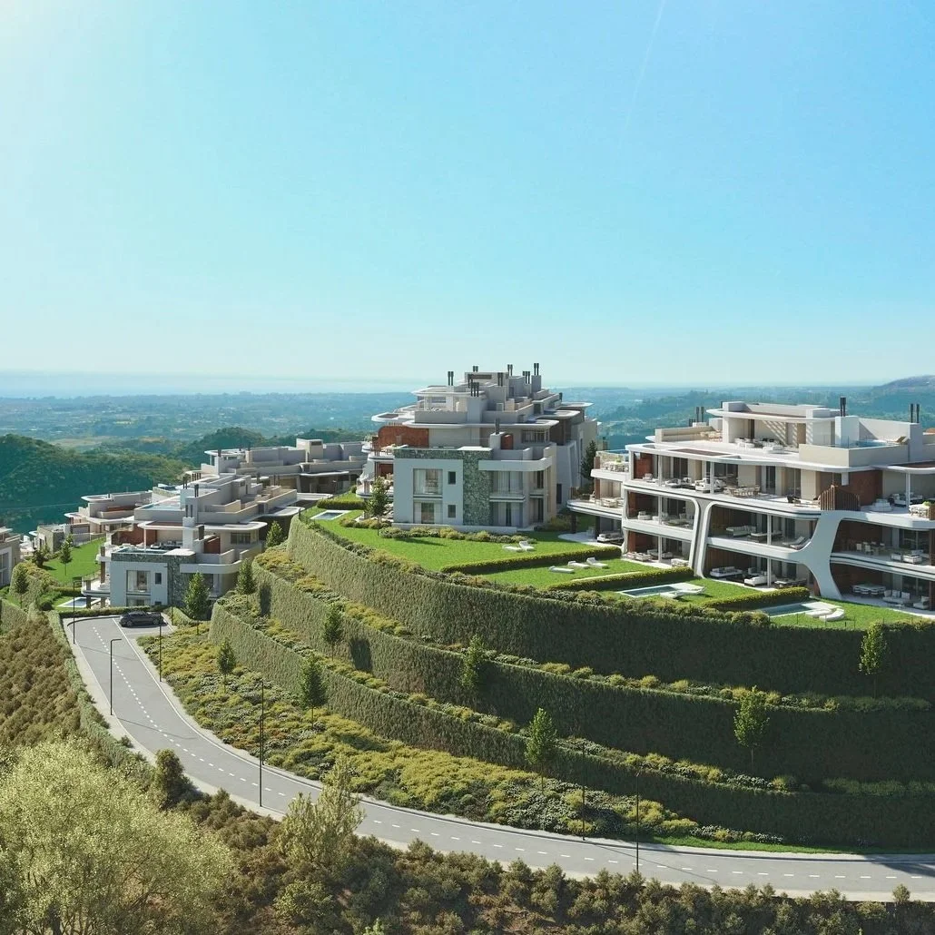 Terraced modern residential buildings in La Quinta Marbella with hillside landscaping and clear skies