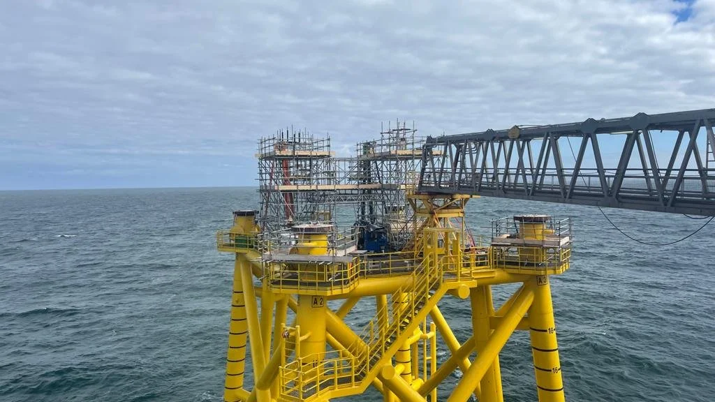 Offshore oil platform in the ocean with a cloudy sky.