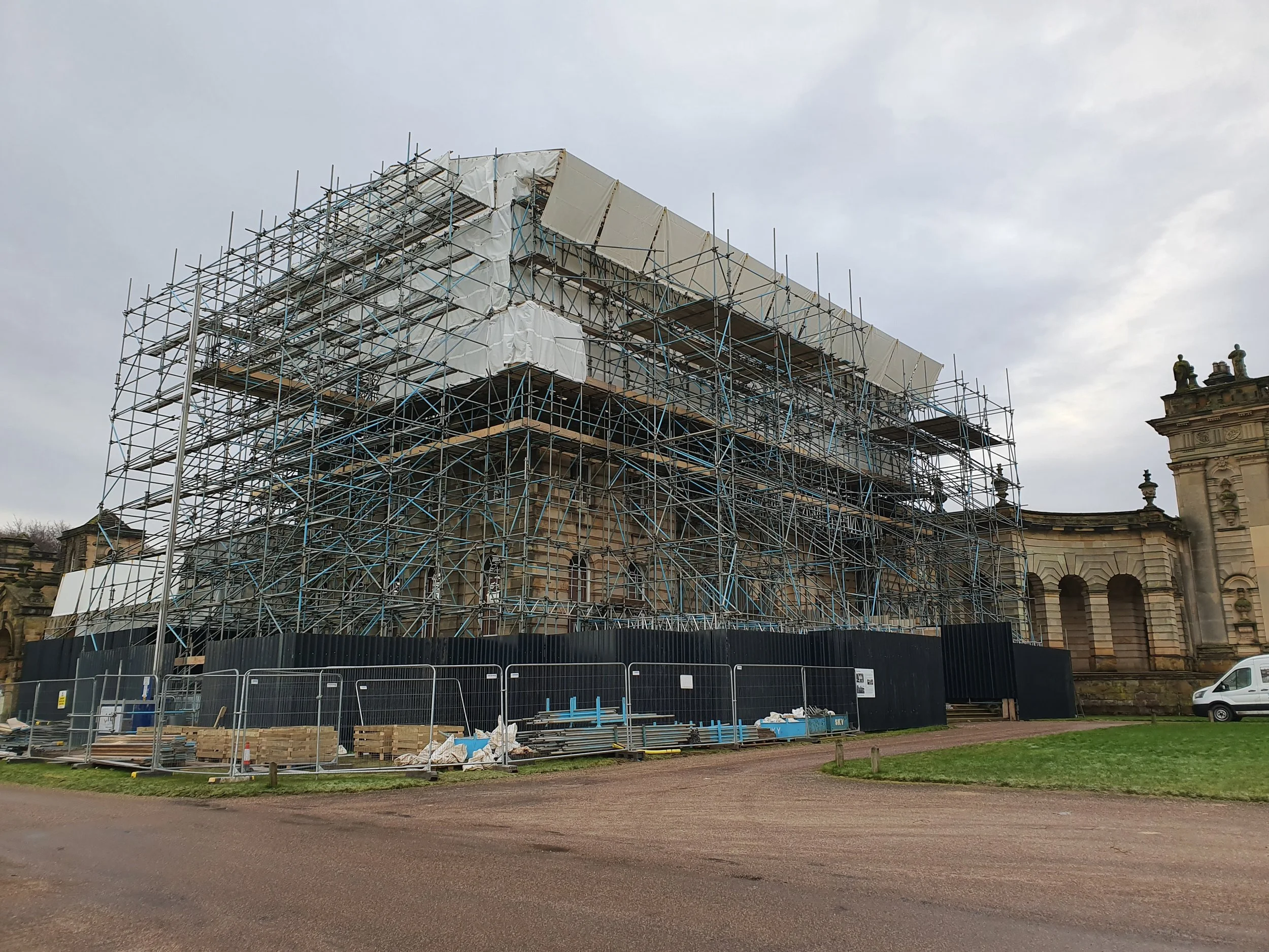A historic building under renovation with extensive metal scaffolding surrounding it.