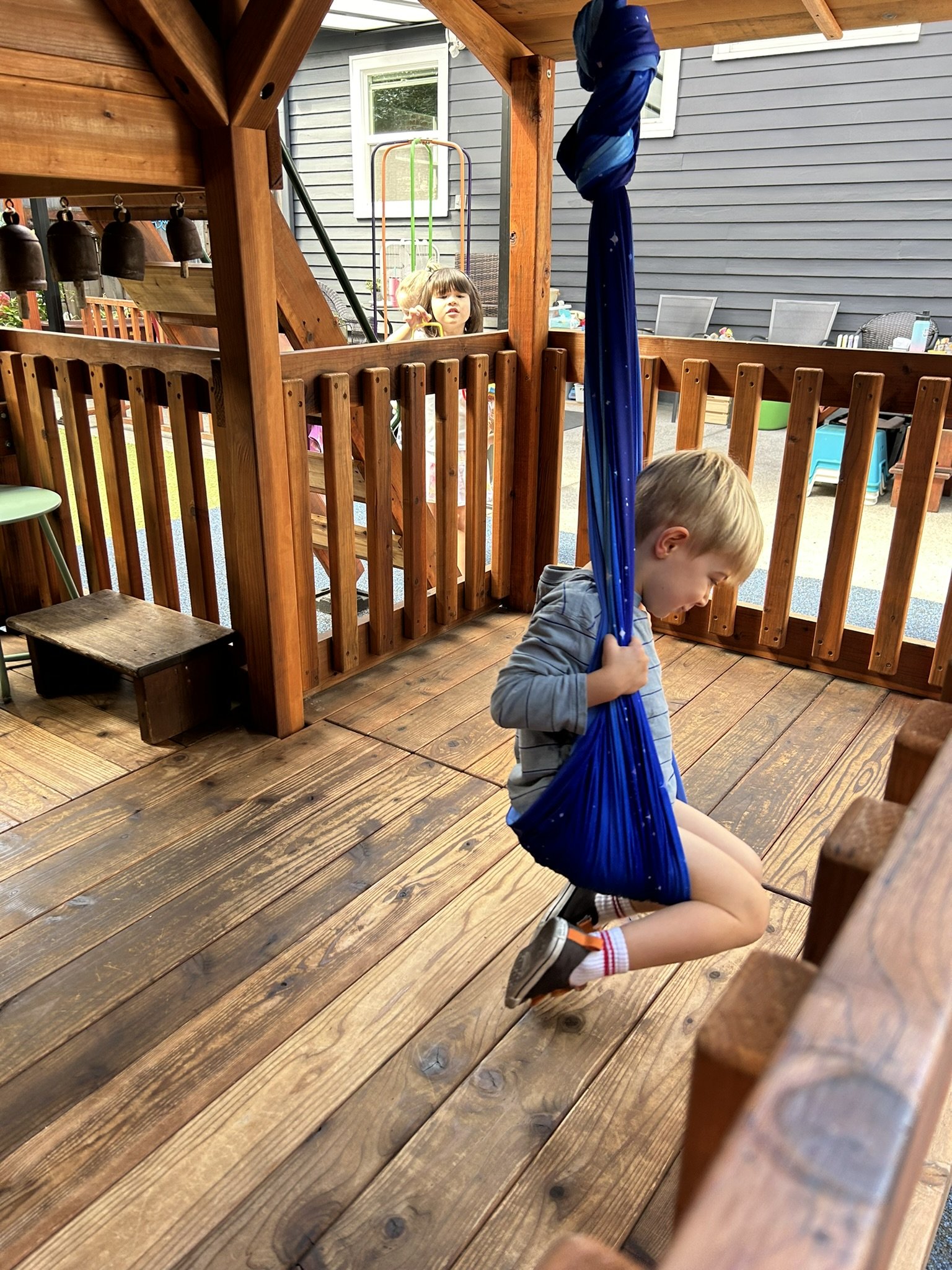 A child playing outside on a swing at Beaumont Children's Center bilingual Chinese preschool in Portland, Oregon