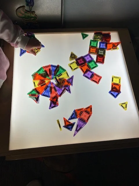 Kids playing with magnetic tiles on a light table at Beaumont Children's Center bilingual Chinese preschool in Portland, Oregon