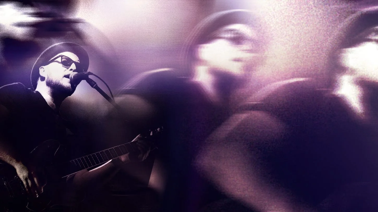 A black-and-white photo of a man singing into a microphone and playing an electric guitar, wearing sunglasses and a hat, with a digital overlay of large, semi-transparent face images in the background.