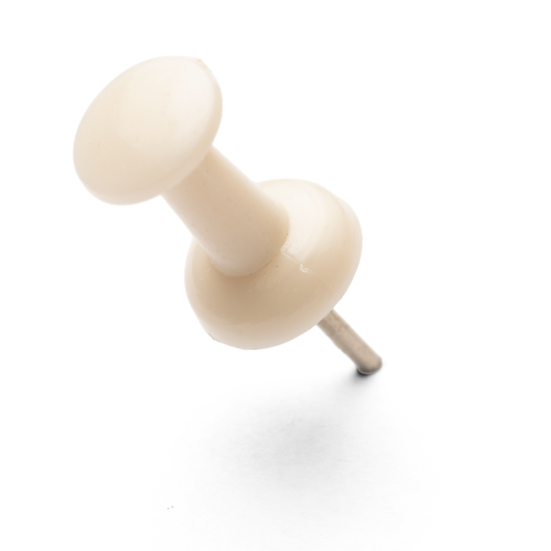 A white push pin with a rounded head and sharp metal point.