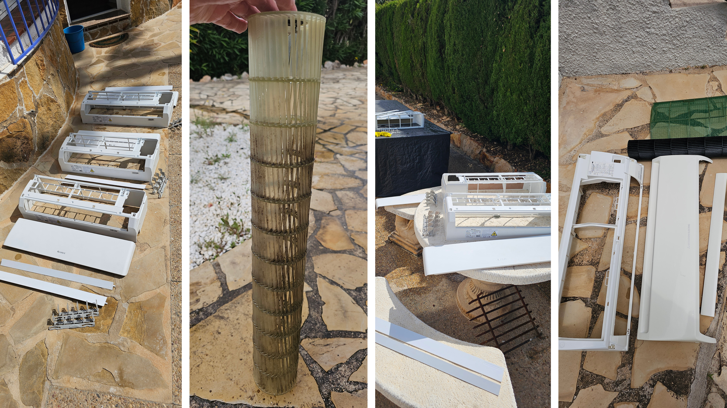 Disassembled white plastic window air conditioner units and parts laid out on a stone patio, with an outdoor garden scene including a stone pillar and paved pathway in the background.