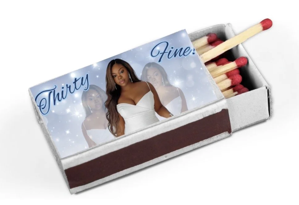 A matchbox decorated with a birthday theme, featuring a woman in a white dress and birthday candles inside.