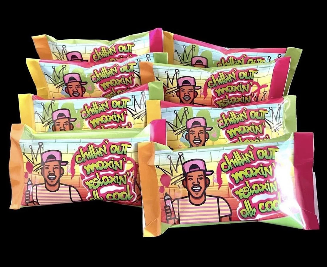 Several colorful packs of candy with cartoon illustrations and text on the packaging, set against a black background.