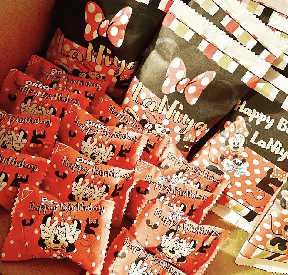 The image shows a collection of Minnie Mouse-themed birthday party favors and decorations. There are party favors with Minnie Mouse and birthday greetings, some with the text "Happy Birthday" and "LaNuyah," featuring Minnie Mouse and her signature po
