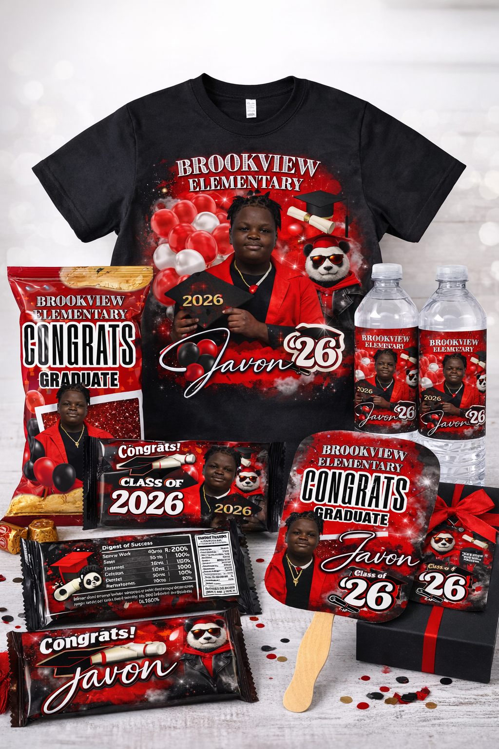 Graduation celebration themed items including a T-shirt, water bottles, snack bags, a paddle sign, and a gift box, all featuring a young graduate in a red blazer and the name Javon, with graduation graphics and decorations.