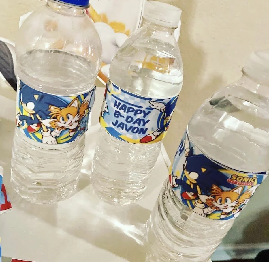 Three plastic water bottles with Sonic the Hedgehog and Tails characters on the labels, one of which says 'Happy B-Day Jaxon.'