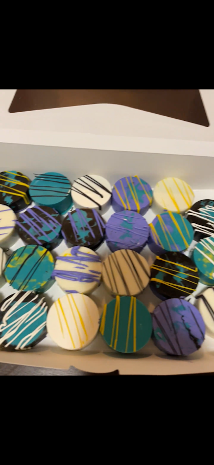 Box of assorted decorated treats with colorful icing and drizzle