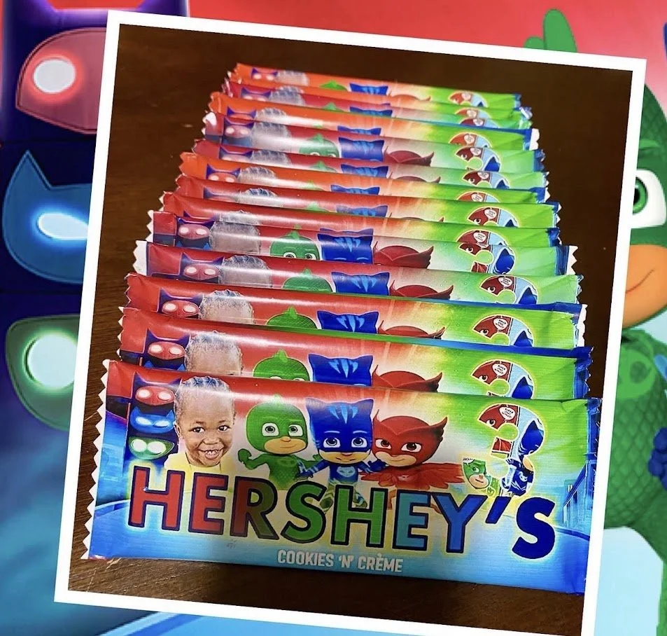 Several Hershey's Cookies 'N Creme chocolate candy bars arranged on a table with colorful background.
