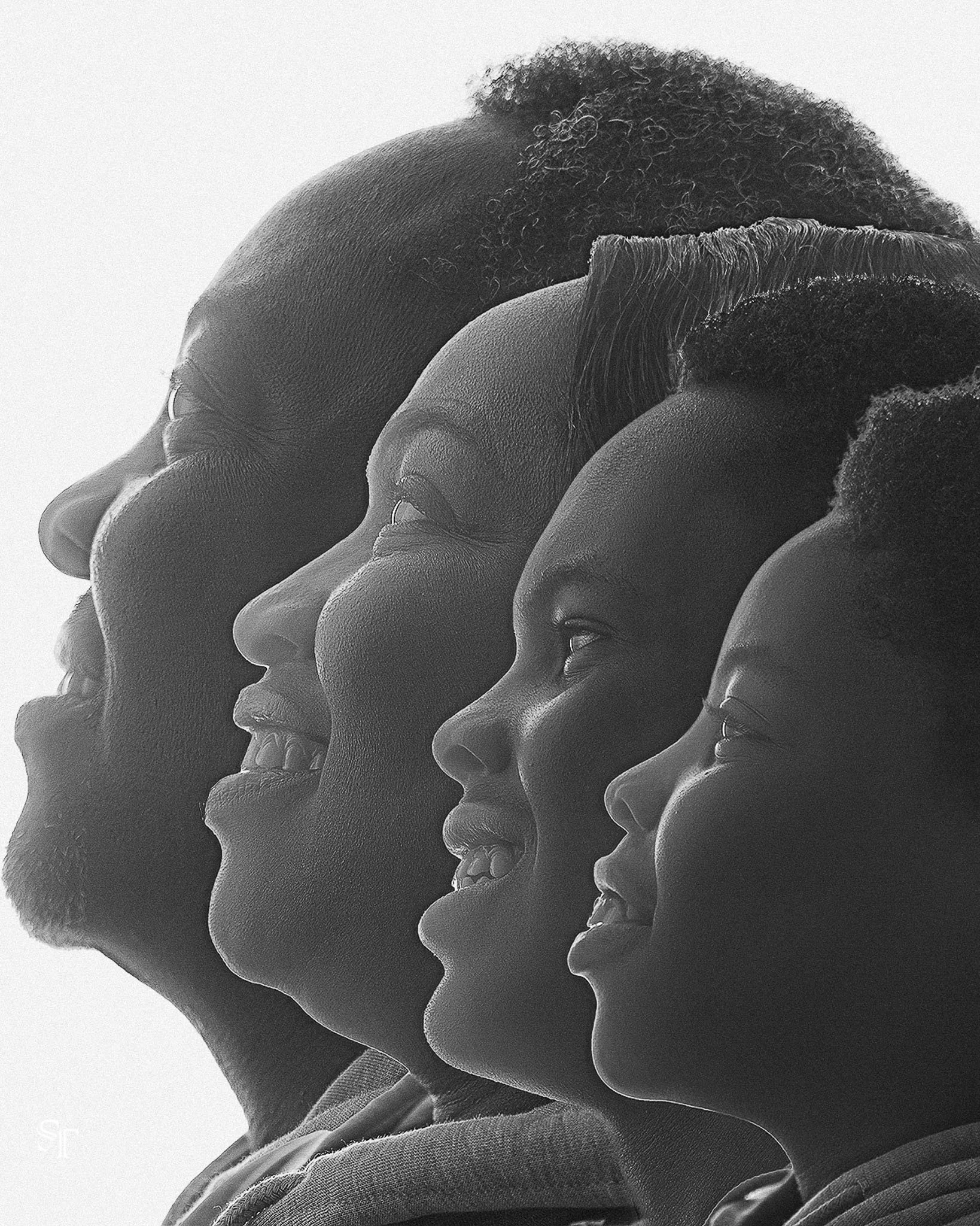 Four Black individuals with a range of ages, smiling and looking to the right, in a close-up black and white photo.