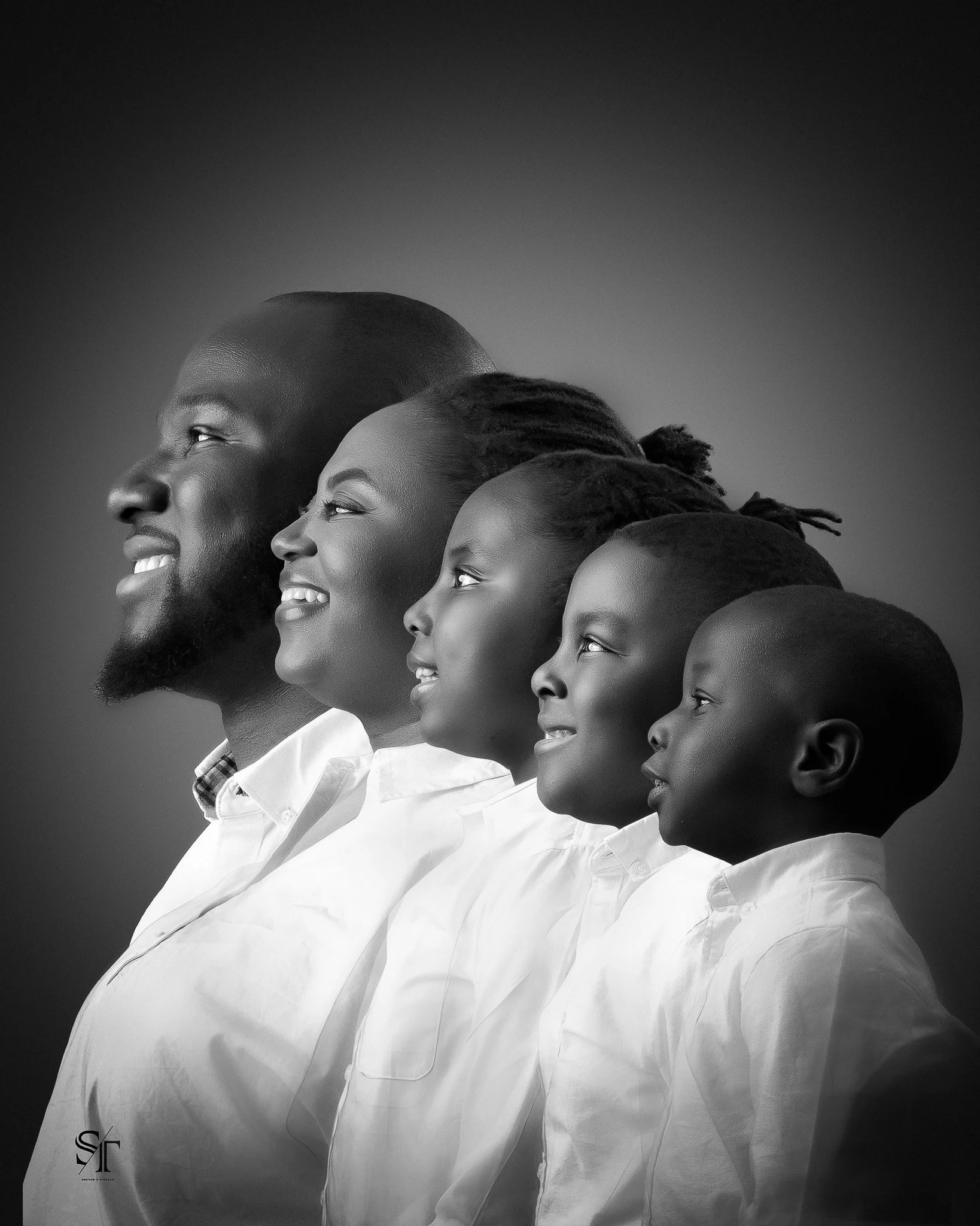 Black and white portrait of a family, including a father, mother, and three children, all dressed in white shirts, looking to the left with smiling expressions.