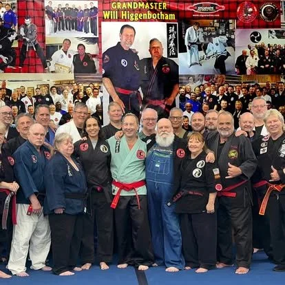 Group of martial artists in uniform celebrating a successful training session or event, with some standing on elevated platforms and others gathered on the ground, in a martial arts dojo.