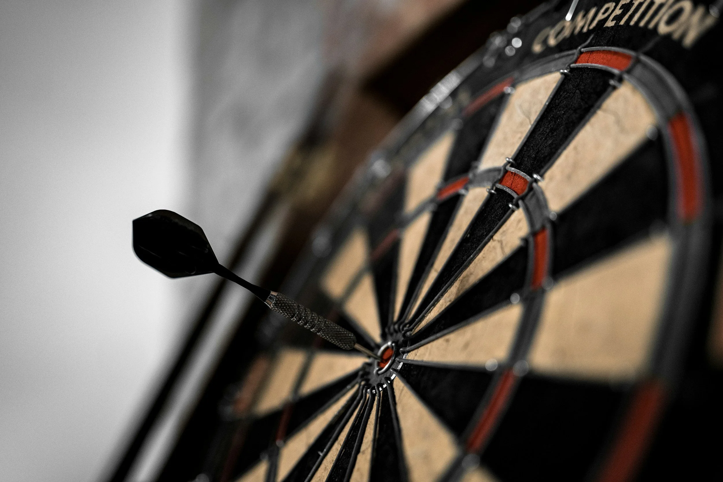 An upclose shot of a dart board with a dart in the middle