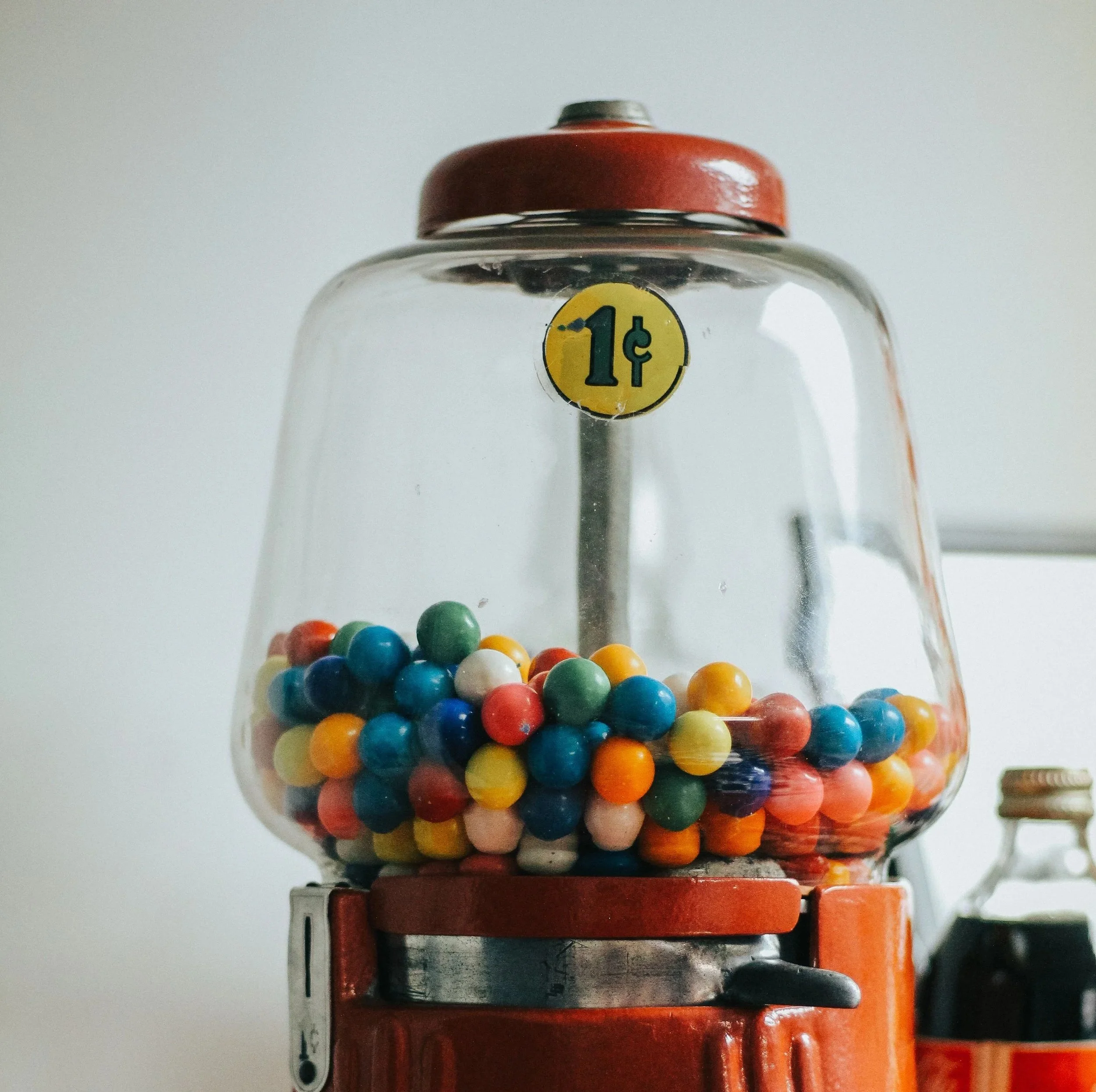 Red penny gumball machine with colorful gumballs