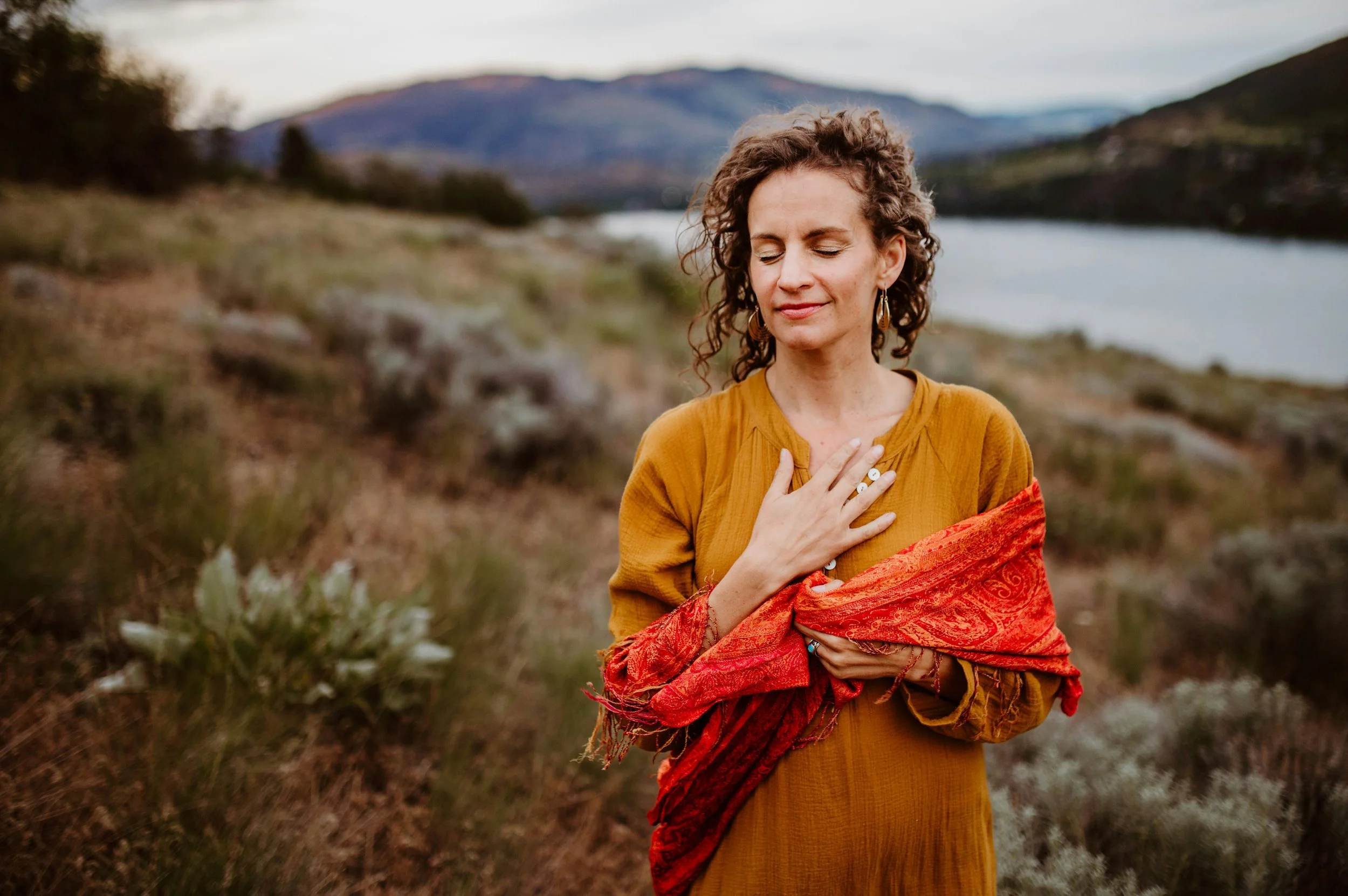 Woman standing outdoors with eyes closed, reflecting self-awareness and emotional connection
