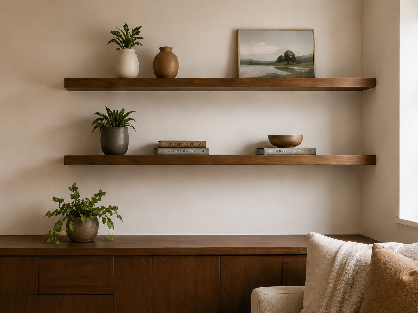 Styled floating shelves above a sofa with plants, books, and decorative accents.