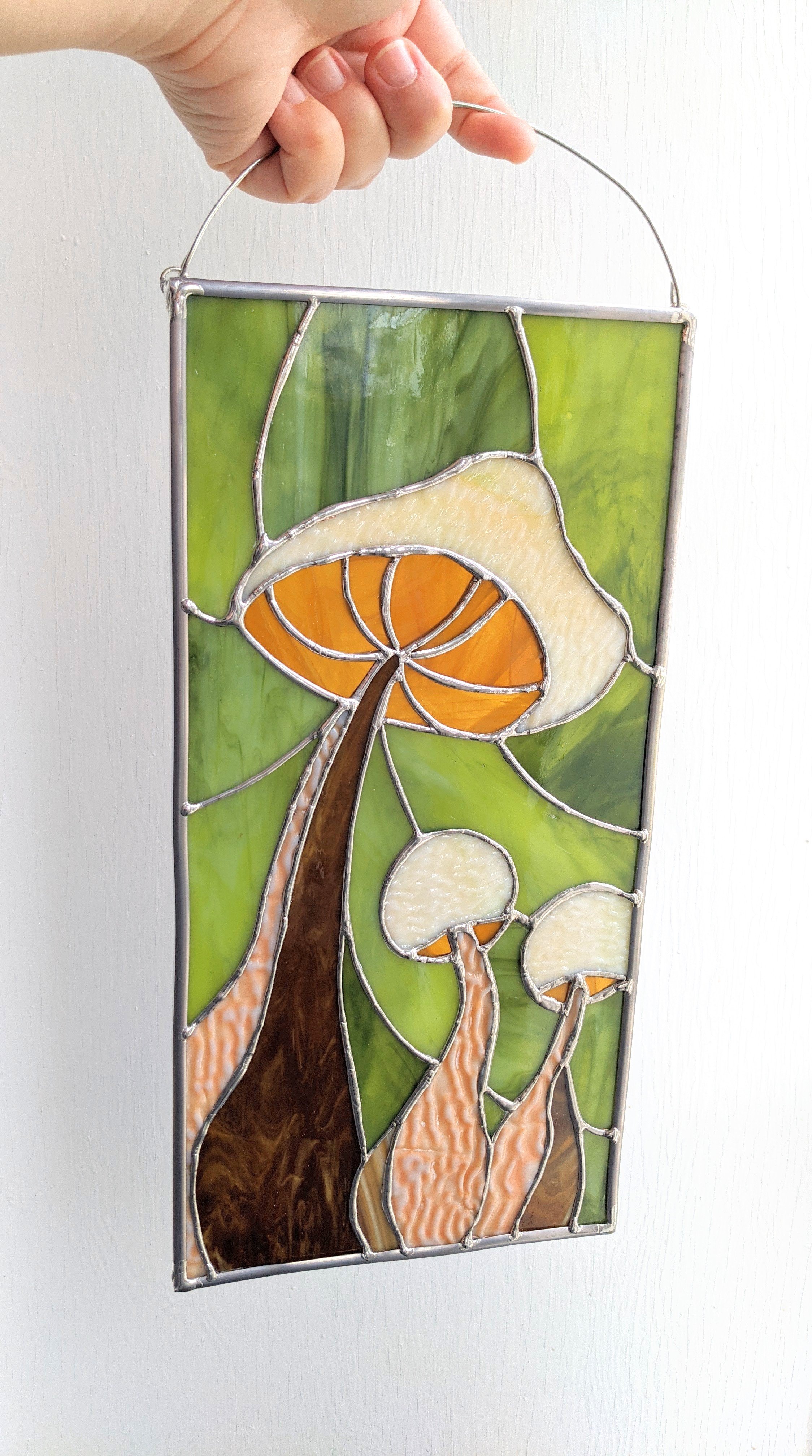 Vintage green and amber glass make up this lovely woodland mushroom stained glass window hanging. 