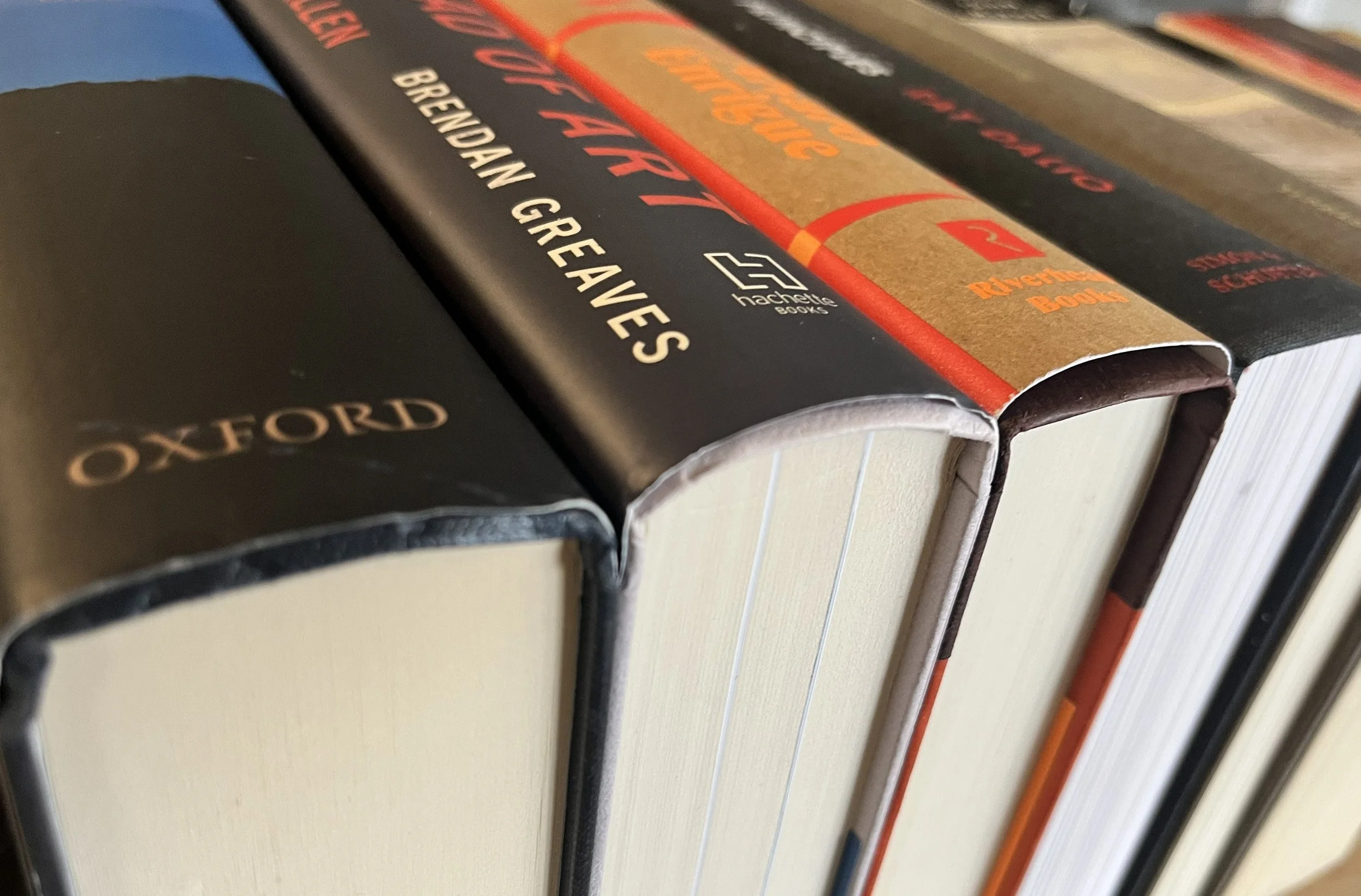 Close-up of several books on a shelf, including 'Oxford' and books published by Hachette Books, with visible titles related to true crime and historical stories.