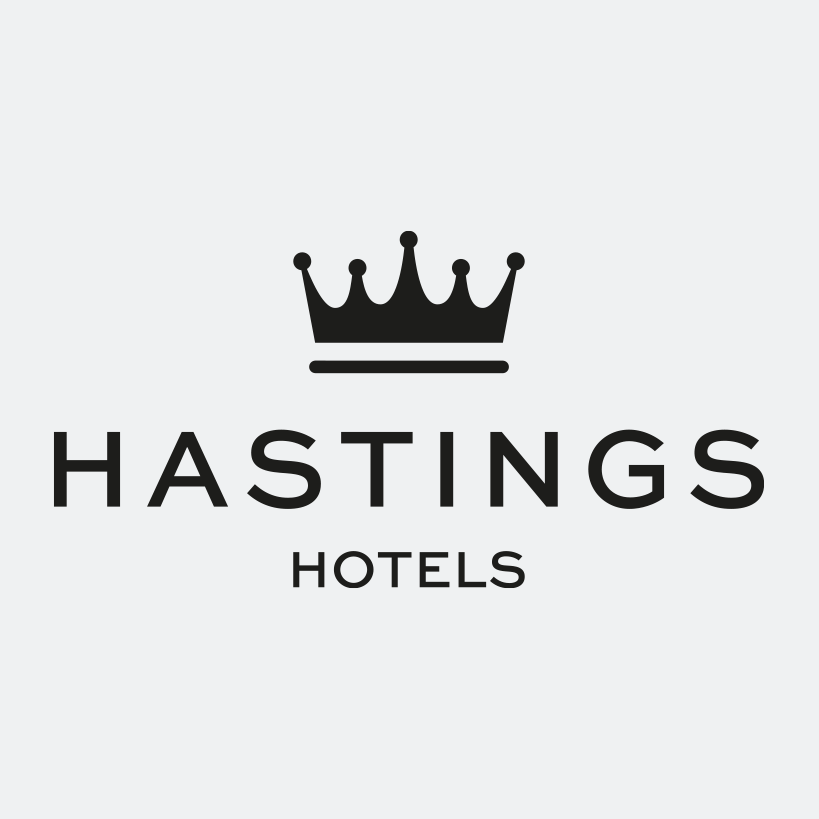Logo for Hastings Hotels featuring a black crown above the name in black text on a light gray background.
