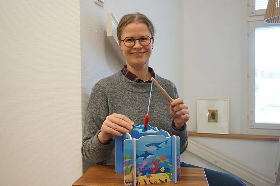 Puheterapeutti Piia Aro-Pulliainen esittelee lasten puheterapiassa käytettäviä välineitä.