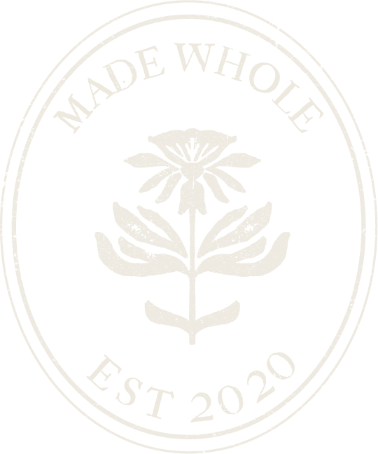 Black circular logo with white text and a floral design in the center. The text reads "Made Wholle" at the top and "Est 2020" at the bottom.