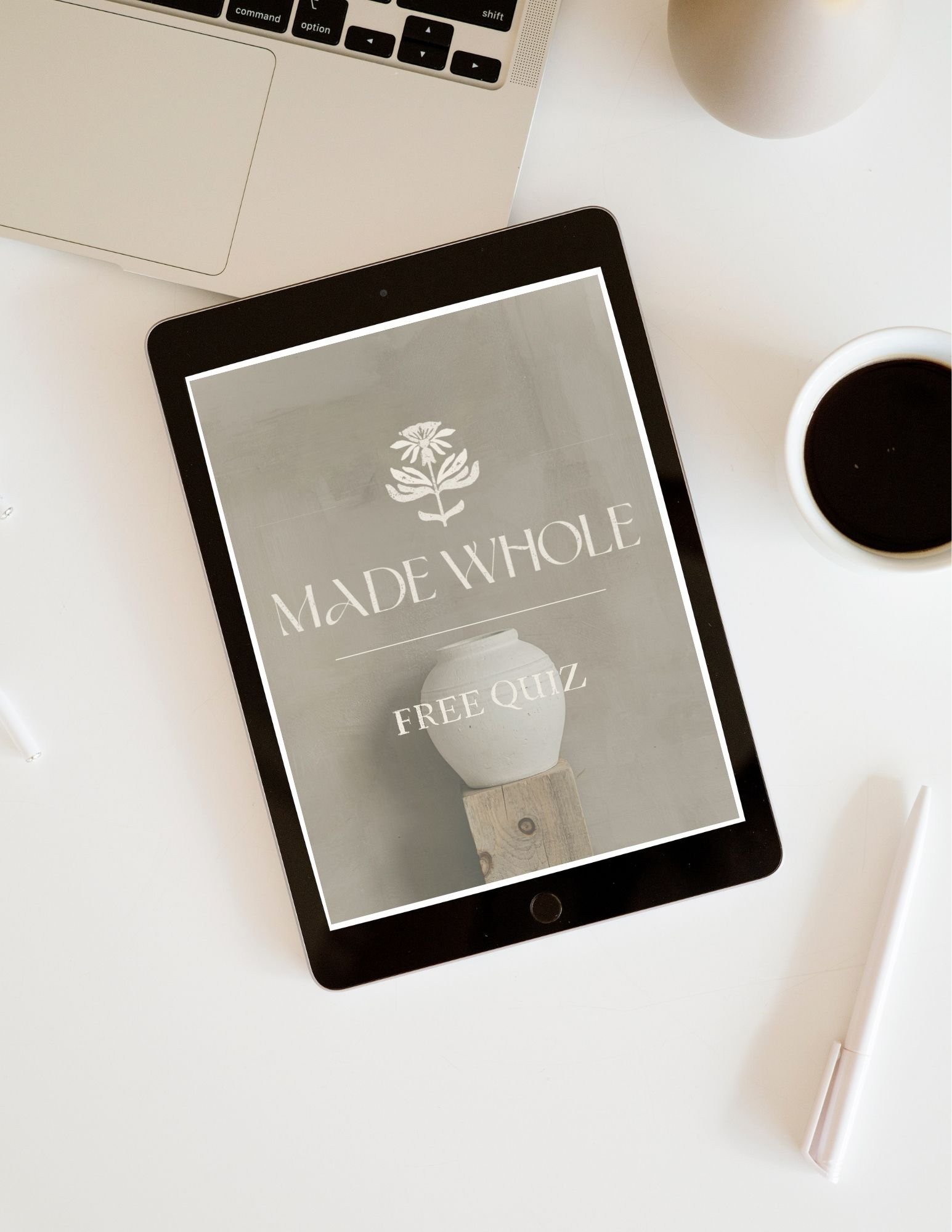 A tablet displaying a logo that reads 'Made Whole' with a flower design and a white vase in the background.