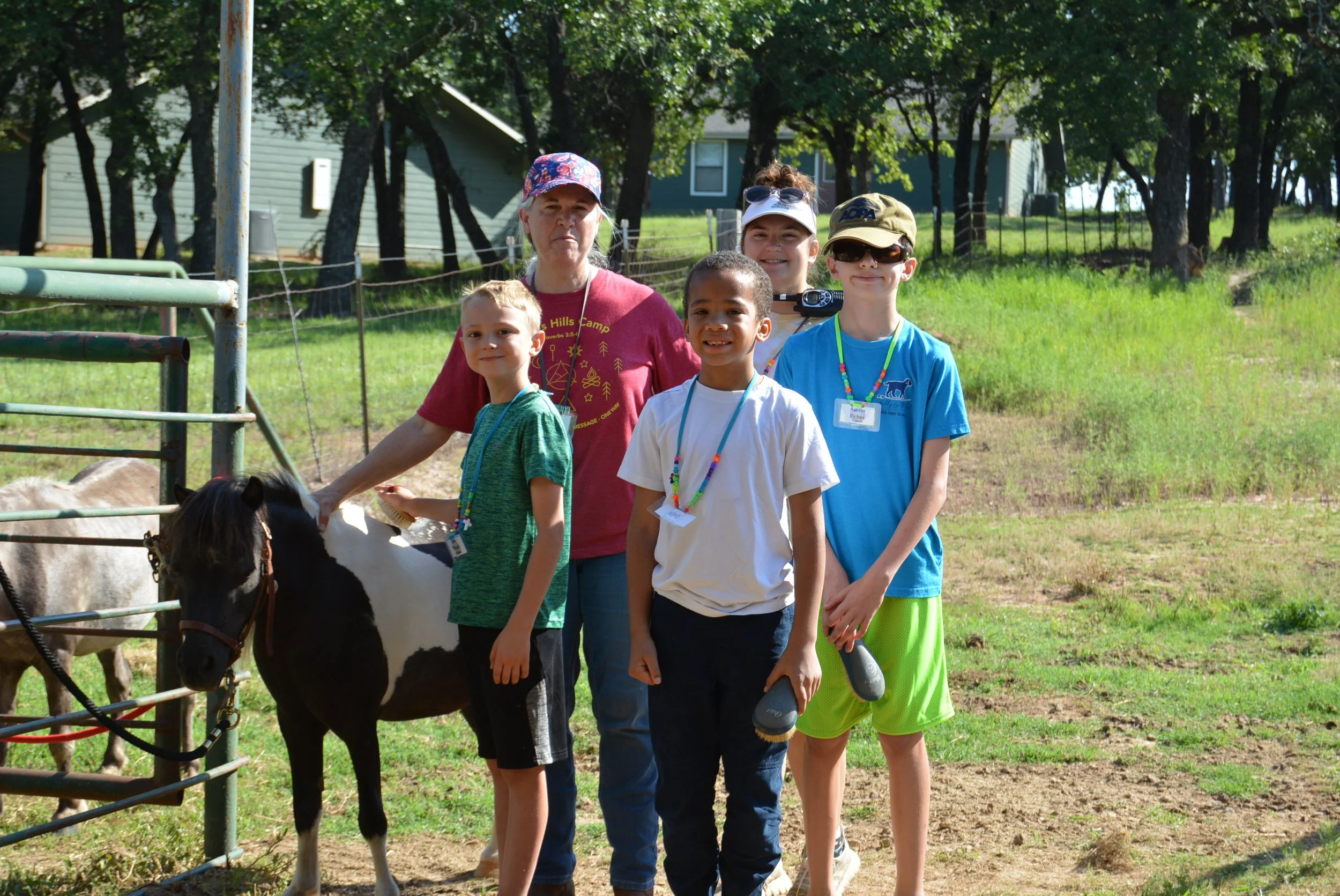 Group of children with a small horse at summer camp