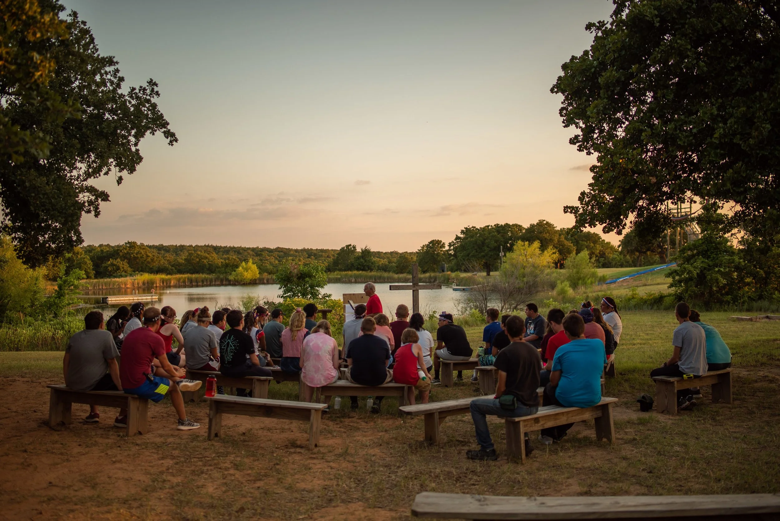 church group gathering by the lake during sunset.