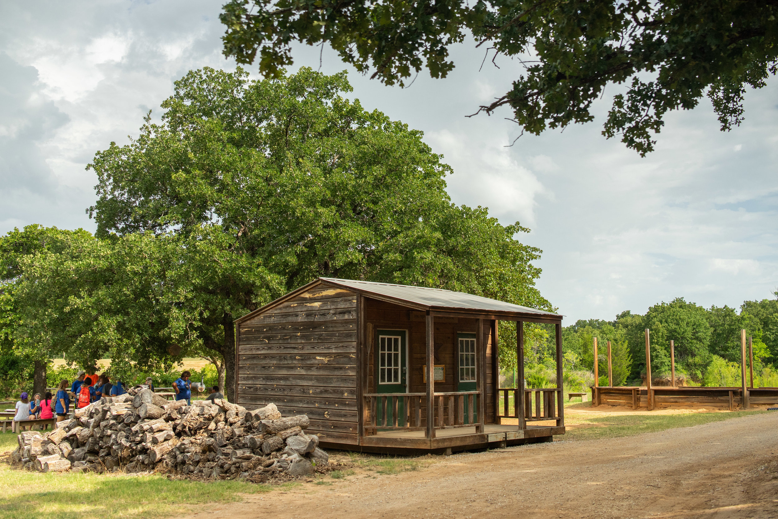 Group near rustic cabin surrounded by trees