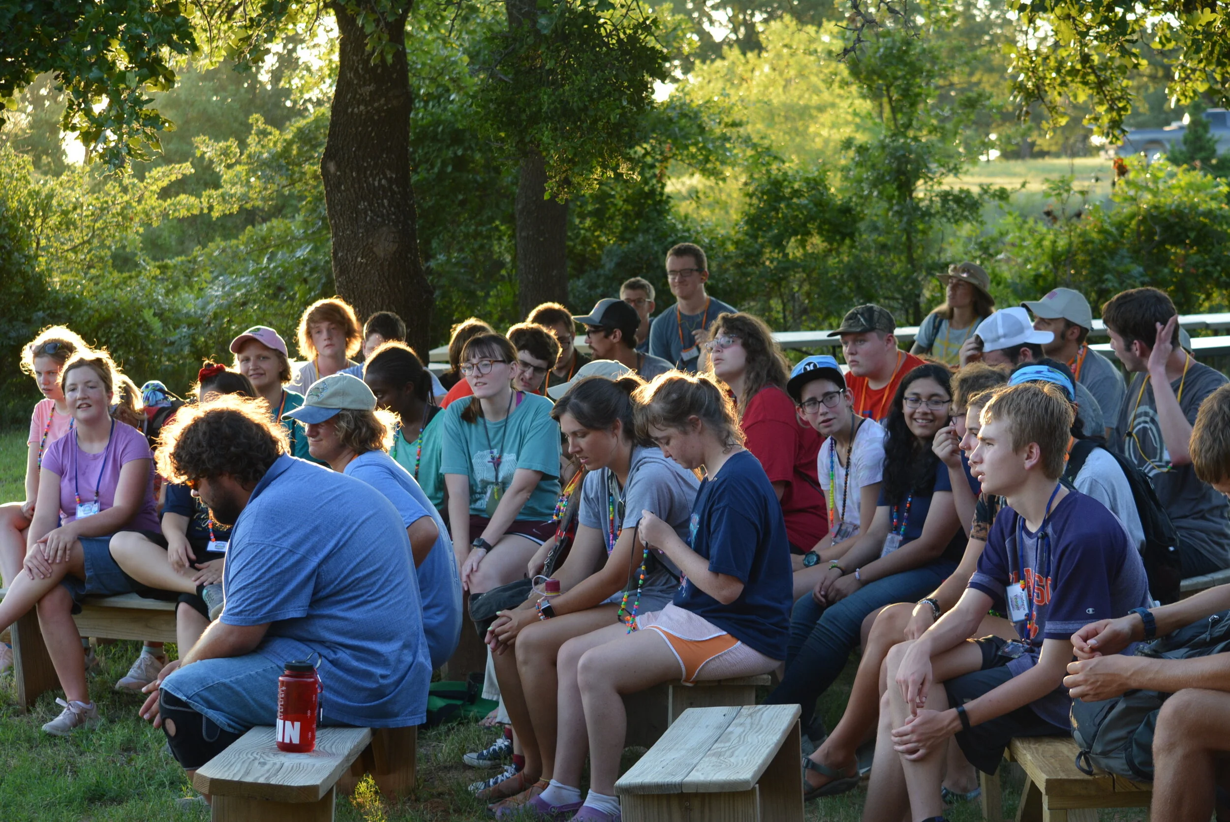 Group of teenagers sitting outdoors at summer camp