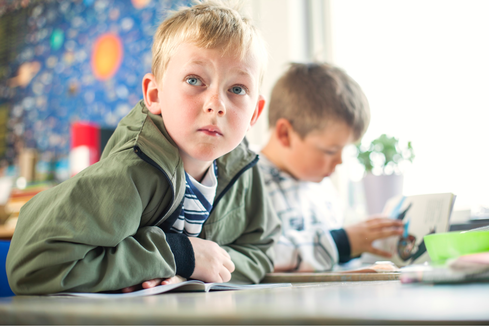 A boy looking off in the distance at school.