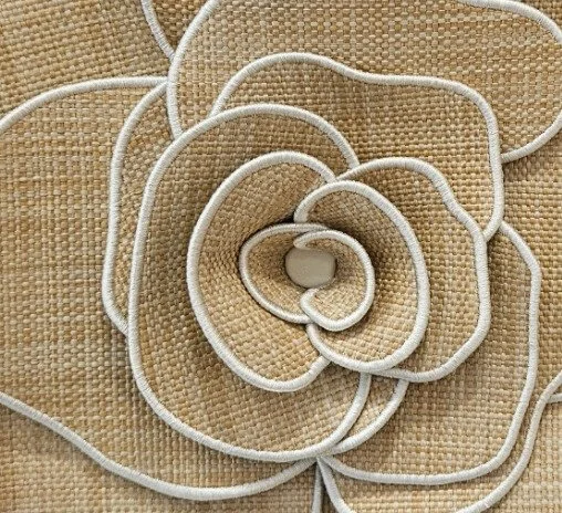 Close-up of a beige woven fabric background with white shoelaces arranged in a spiral shape.
