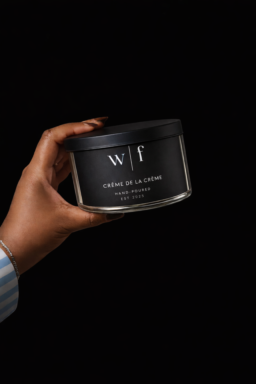 Elegant hand with luxury candle tin.png