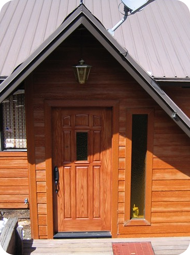 Front door of a wooden house with window and porch.