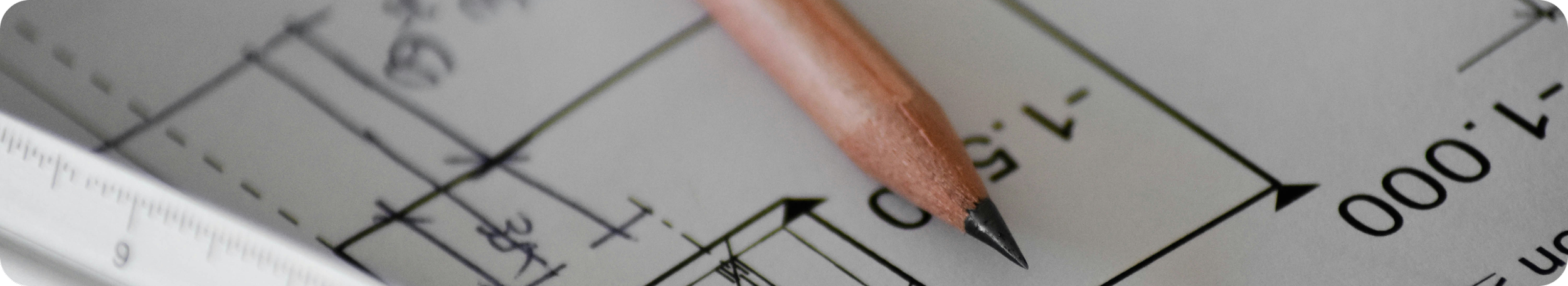 Close-up of a wooden pencil resting on a technical drawing or blueprint with measurements and lines.