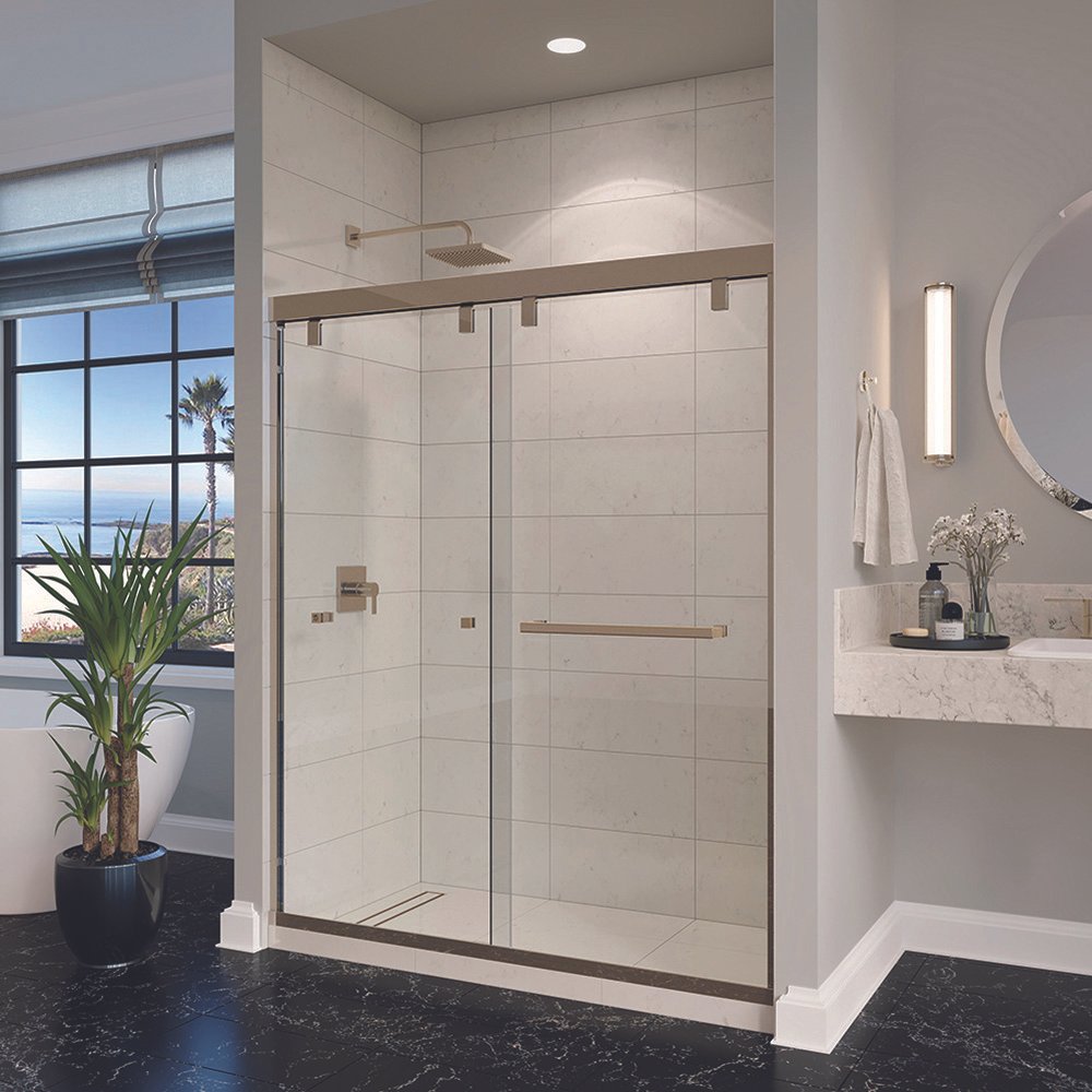 Modern bathroom with a glass shower enclosure, a round mirror, a marble countertop with a vase of white flowers, a towel rack, and a large window with a view of palm trees and the ocean.