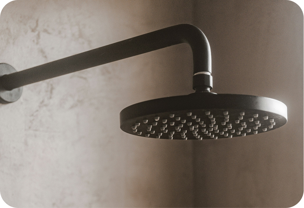 Close-up image of a black showerhead mounted on a wall.