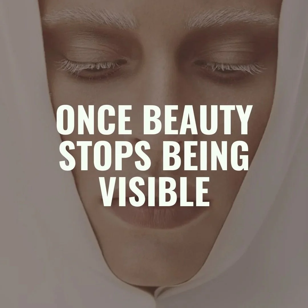 Close-up of a person's face with closed eyes and a neutral expression, with bold white text overlaid that says, "Once beauty stops being visible."