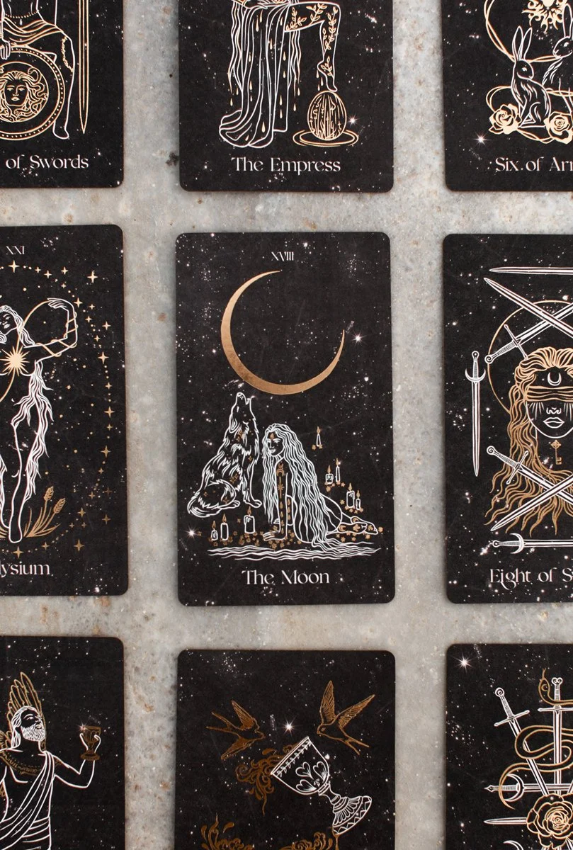 Tarot card deck featuring the Moon card with a person and a wolf under a crescent moon, set against a starry background.