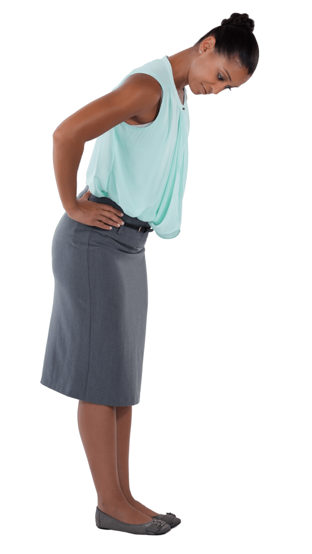 Donna in abiti da ufficio con espressione pensierosa, tiene le mani sulla schiena e guarda verso il basso