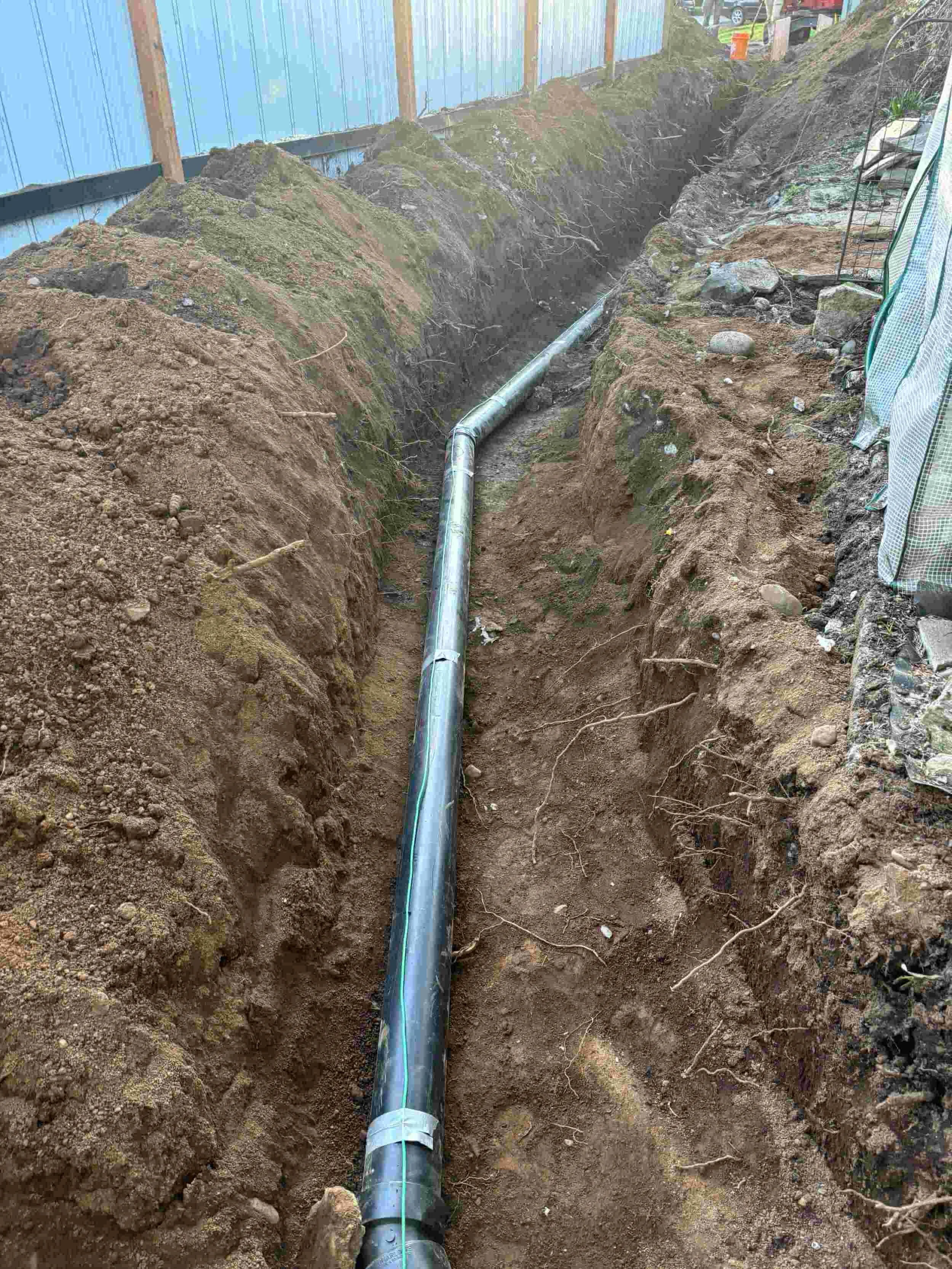 Underground pipe installation in a trench at a construction site.