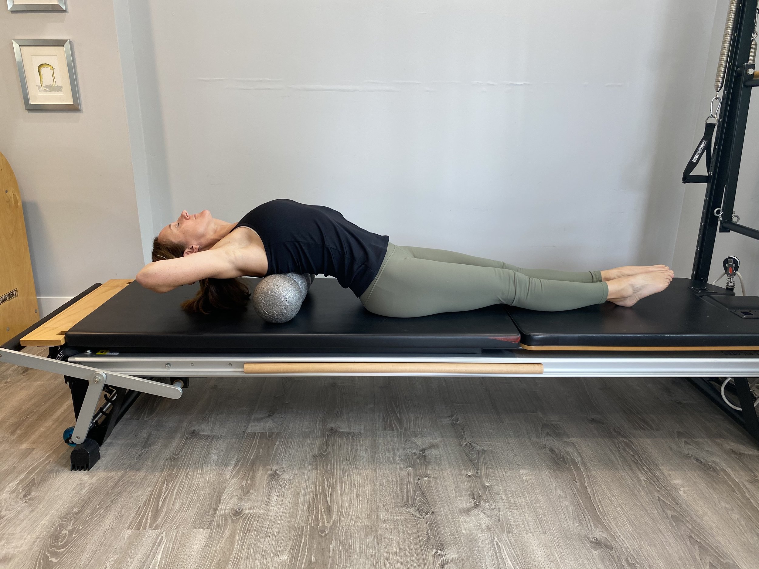 Midde-aged female on a foam roller, moving joints and staying supple