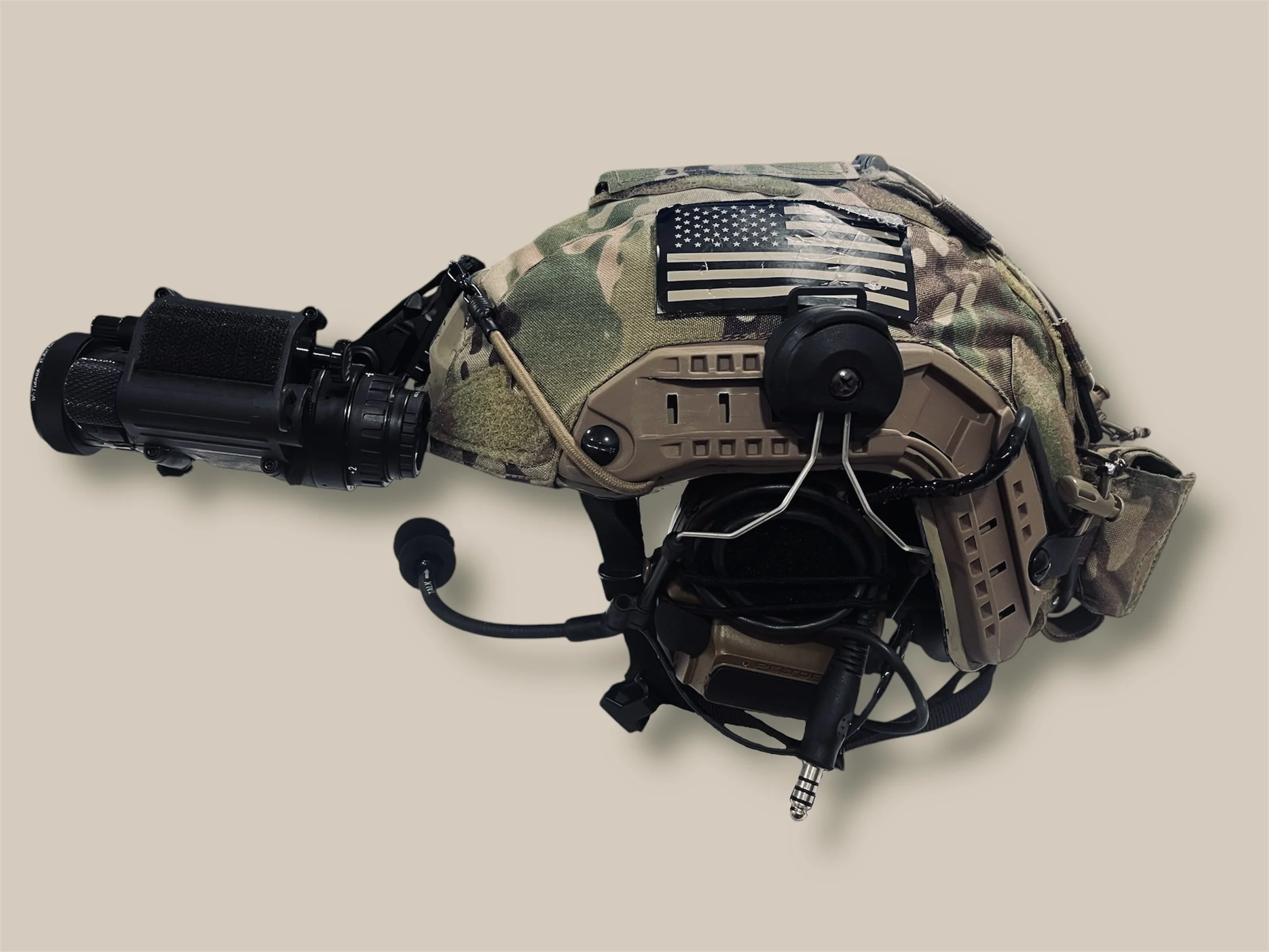 Military tactical backpack with a patch of the American flag on it, attached to a robotic device or drone.