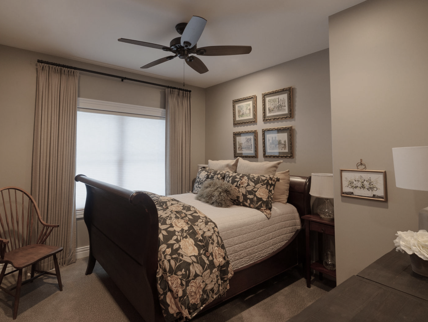 Antique sleigh bed in guest bedroom. Floral duvet cover and shams. Linen coverlet. Custom drapery. Pale linen sage walls. Antique barrel chair. Featherstone Interior Design.